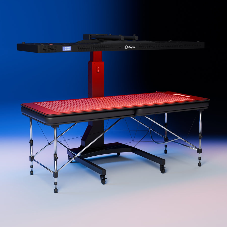 Oxydise Red Light Panel on its height-adjustable stand above a massage table with the Oxydise PEMF Mat